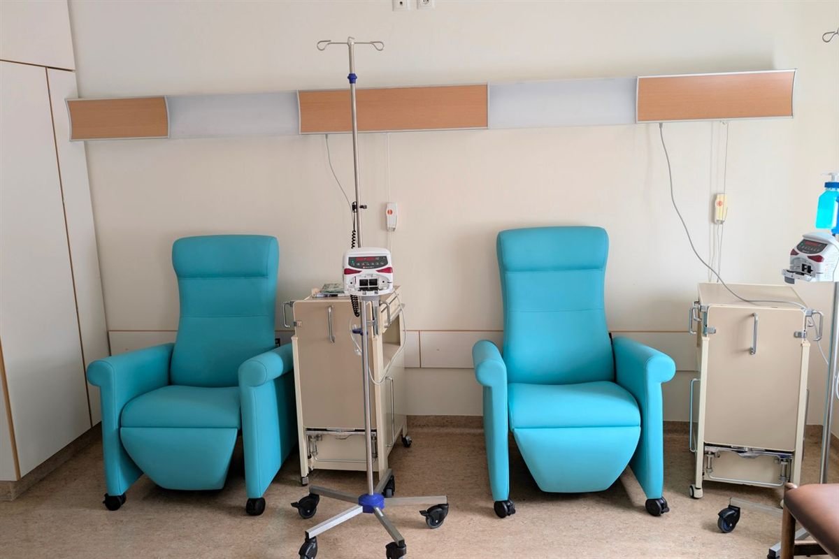 Empty infusion chairs and IV poles in a calm, quiet chemotherapy treatment room
