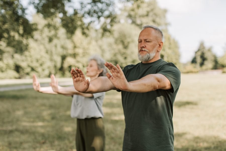 Senior couple stretching together outdoors in a park