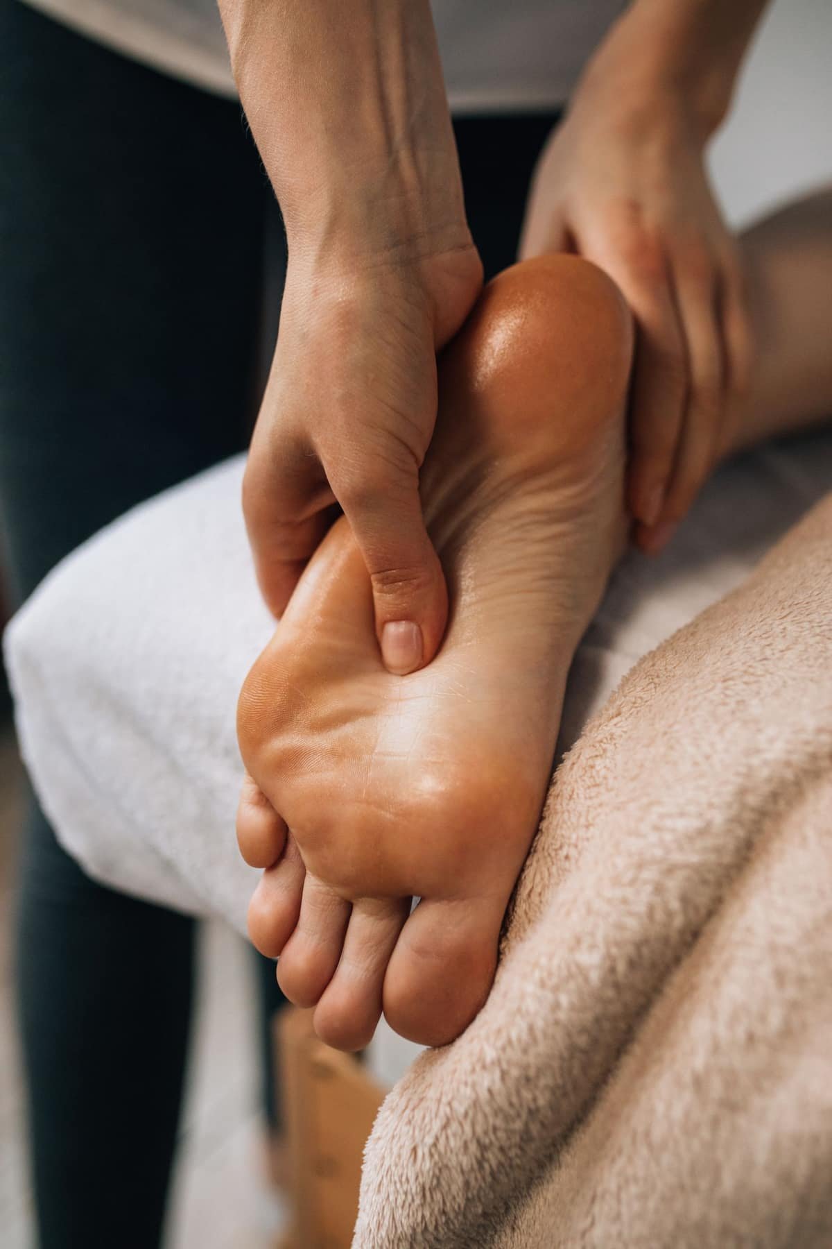 Close-up of hands massaging the sole of a foot